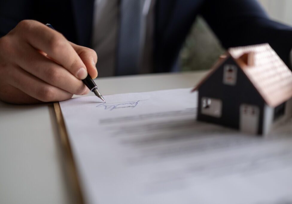 Businessman signing a legal real estate contract agreement, home Insurance.